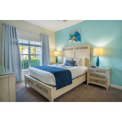 Immerse yourself in this calming blue bedroom, where a plush bed, chic nightstands, and soft curtains create a cozy retreat. The natural light streaming in enhances the inviting ambiance, making it an ideal place to relax.