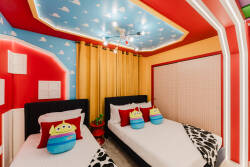 Experience a playful atmosphere in this enchanting bedroom with brightly colored walls and whimsical cloud patterns. Two cozy beds with fun character pillows and a unique ceiling design make it an ideal family space.