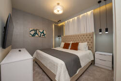 Experience restful nights in a beautifully designed bedroom featuring a plush tufted headboard and cozy neutral bedding. Warm lighting from stylish pendant fixtures creates an inviting atmosphere for your perfect sanctuary stay.