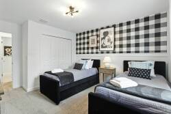 This bright and clean room offers two cozy twin beds with stylish bedding for a restful night's sleep. The bold black-and-white plaid accent wall and modern artwork add a lively touch to the decor.