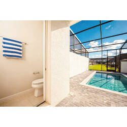 Enjoy your private oasis with a stunning pool area, featuring sleek pavers and a sparkling pool ideal for refreshing swims. Relax on the sun loungers under the spacious screened enclosure, the perfect place to unwind and recharge.
