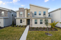 Discover a charming exterior with a mix of light stucco and textured stone that creates a warm welcome. The manicured lawn and bright façade invite you to explore the beautifully designed interior just inside the front door.