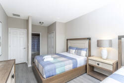 This bright bedroom offers a cozy queen bed with a soft, colorful quilt and warm wood furniture. Enjoy the natural light that fills the space, creating a welcoming atmosphere perfect for unwinding after your adventures.