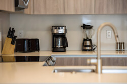 Experience a culinary haven featuring sleek cabinetry and a pristine countertop that showcases modern appliances like a coffee maker and blender. The inviting layout encourages both cooking and stylish gatherings with loved ones.