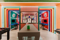 Enter a lively game room with a colorful backdrop that energizes the atmosphere. A stylish table and foosball setup encourage friendly competition, while the playful decor ensures fun-filled evenings with family and friends.