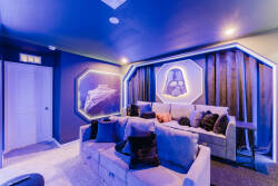 Step into a captivating media room, where plush seating adorned with soft pillows invites you to unwind. The deep blue walls and creative lighting create an immersive atmosphere, perfect for movie nights or gaming adventures.