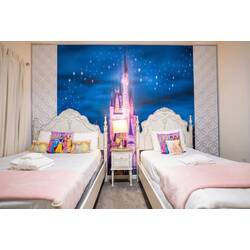 Rest in a dreamy princess-themed bedroom with two cozy beds, elegant white headboards, soft pink accents, and a magical castle mural under a starry sky. Playful pillows and gentle lighting create a sweet space for vacation.