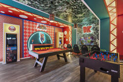 Enjoy a colorful Super Mario themed game room designed for endless fun, featuring arcade machines, a pool table, foosball, gaming chairs, and a wall-mounted TV. Bright colors, playful character details, and fun lighting create the perfect entertainme