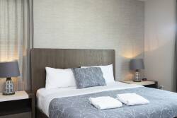 Enjoy restful nights in this beautifully designed bedroom with a plush king-size bed, crisp linens, and soothing colors. The soft lighting from stylish lamps enhances the tranquil ambiance, making it perfect for relaxation.