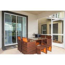 Enjoy the screened patio with outdoor dining, lounge chairs, private pool, relaxing spa, sunny views, and open green surroundings, perfect for peaceful moments by the water.