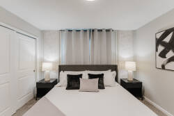 Experience tranquility in this cozy bedroom with a plush queen bed and soft linens. Stylish nightstands and elegant lamps provide a warm glow, while modern accents and subtle artwork create a peaceful retreat for your relaxation.