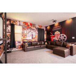 Enjoy a cozy cinema-themed theater room with a large projector screen, plush sectional seating, and warm ambient lighting. Brick accents, vintage movie posters, and playful popcorn decor create the perfect spot for family movie nights.