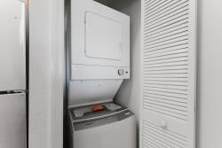 This convenient laundry nook features a sleek stacked washer and dryer, allowing you to easily enjoy fresh clothes during your stay. Its clean, white design blends beautifully with the space, combining practicality and style.