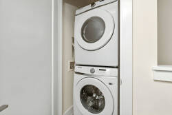 Experience comfort and convenience in this well-designed laundry nook, complete with a sleek stacked washer and dryer. Its clean lines and neutral tones make it easy to keep your clothes fresh during your stay.