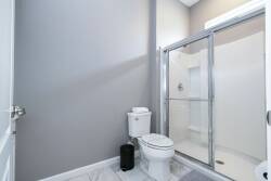 Discover a refreshing bathroom featuring sleek gray walls and elegant marble flooring that exudes sophistication. The modern glass shower offers a bright, airy feel, making it an ideal spot to unwind after a day of adventure.