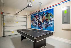 Have fun in a superhero themed game garage with a ping pong table, bold wall art, bright lighting, and open space, creating a great area for family entertainment during vacation.