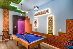 Welcome to our vibrant game room featuring a striking blue pool table surrounded by playful Minecraft-themed decor and creative lighting. The colorful walls and unique textures set the stage for fun and friendly competitions.