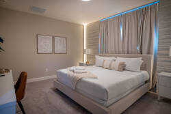 This cozy bedroom features soft tones and plush carpeting, inviting you to unwind. Natural light filters through the elegant curtains, highlighting the modern decor and creating a tranquil atmosphere for restful nights.