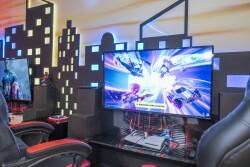 Welcome to a gamer's paradise, featuring sleek black chairs and a vibrant city skyline wall. Enjoy immersive play on a large monitor that delivers dynamic visuals for endless entertainment. Immerse yourself in the experience!