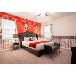 Relax in a stylish Mickey-themed bedroom with a bold character mural, elegant tufted headboard, soft carpet, and playful red, black, and white accents. Bright windows, cozy lighting, and fun Disney-inspired details create a cheerful and comfortable r