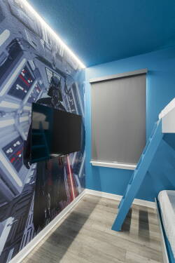 Welcome to a vibrant retreat for adventure lovers, featuring a striking blue mural and cozy nights with a flat-screen TV. Climb the playful ladder to your lofted bed, perfect for restful slumbers after a day of excitement.