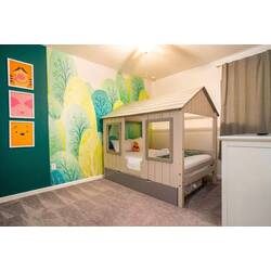 Rest in a sweet forest-themed kids bedroom with a charming house-style bed, soft carpet, playful character art, and a colorful nature mural. Cozy bedding, warm lighting, and cheerful details create a fun space for vacation.