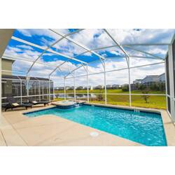 Enjoy a screened outdoor pool area with a private pool, relaxing spa, lounge chairs, sunny patio, and peaceful lake views, perfect for soaking up the Florida weather.