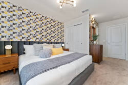 Welcome to this beautifully designed bedroom, where stylish patterned wallpaper and soft, neutral bedding create a cozy ambiance. With warm wood accents on the nightstands, this space promises you restful and inviting nights.