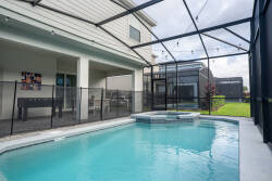 Step outside to your private pool area, where sunlight glimmers on the water. The elegant deck and screened enclosure provide comfort and privacy, creating the perfect spot to enjoy a relaxing afternoon amidst lush greenery.