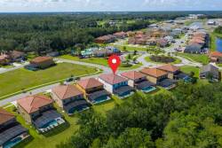 This aerial view reveals a lively community with beautiful homes and greenery, inviting you to explore nearby amenities. Enjoy the spacious layout and closeness to sparkling pools, ideal for a relaxing day in the sun.