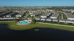 Experience the charm of community living with a stunning view of the tranquil lake and landscaped grounds. The inviting pool area glistens under the bright sun, perfect for unwinding after a day of adventure.