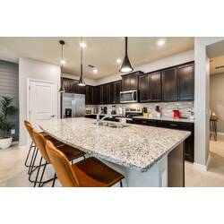 Welcome to this stylish kitchen with elegant dark cabinetry and gleaming granite countertops that inspire your culinary creativity.