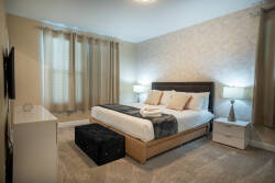 Enjoy restful nights in this cozy bedroom with a plush queen bed, soft linens, and elegant bedside lamps. The warm decor and natural light create a welcoming atmosphere for your stay.