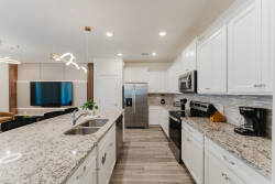 Welcome to this beautifully designed kitchen with sleek white cabinets and gorgeous granite countertops, perfect for culinary adventures. The open layout flows into the living area, bathed in natural light and modern lighting.