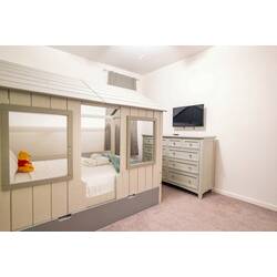 Rest in a cozy kids bedroom with a charming house-style bed, soft carpet, wall-mounted TV, and spacious dresser. Light tones, warm bedding, and playful details create a comfortable space for little guests during vacation.