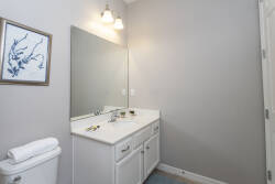 Experience a bright and airy bathroom with a spacious double vanity, polished countertops, and plenty of storage for your relaxation after a day of adventure. The soft gray walls and stylish lighting create a soothing atmosphere.