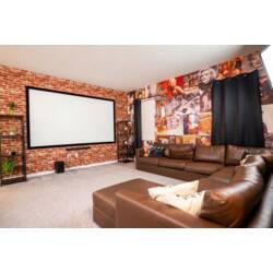 Enjoy a cozy cinema-themed theater room with a large projector screen, plush sectional seating, and warm ambient lighting. Brick accents, vintage movie posters, and playful popcorn decor create the perfect spot for family movie nights.