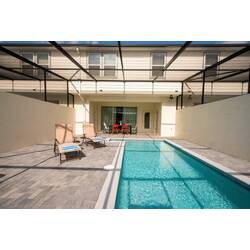 Enjoy your private oasis with a stunning pool area, featuring sleek pavers and a sparkling pool ideal for refreshing swims. Relax on the sun loungers under the spacious screened enclosure, the perfect place to unwind and recharge.