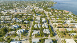 Discover the charm of coastal living with breathtaking views of tree-lined streets and sparkling waterways, as the vibrant community invites you to explore its blend of beautiful homes and lush greenery.