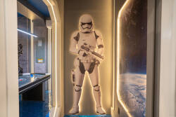 Enter a unique corridor featuring a life-size Stormtrooper cutout and ambient lighting that sets a playful tone. The futuristic decor and space-themed accents invite you to dive into a world of imagination.