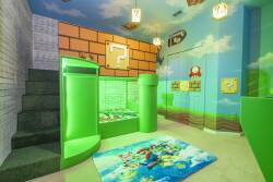 Step into a vibrant gaming haven where whimsical decor meets playful design, featuring bright green structures and a colorful mural. The cozy rug adds a touch of comfort, inviting hours of fun and creativity for all ages.
