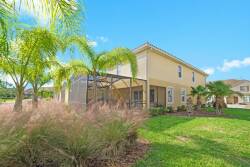 Step outside to experience the lush greenery around this charming vacation home, where palm trees sway in the breeze. The spacious lawn invites relaxation, and the screened-in porch offers a bug-free space for dining or lounging.