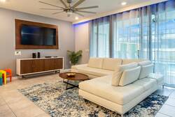 Relax in a bright living room with a cream sectional, wall-mounted TV, ceiling fan, soft curtains, blue accent lighting, and a stylish rug, creating a comfortable space for family vacation moments.