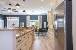 Experience a delightful kitchen with elegant granite countertops and soft white cabinets that brighten the space. Rich blue walls provide a stunning backdrop, while modern lighting and an open layout make cooking and gathering.