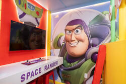 Step into a vibrant playroom where kids can unleash their imagination, featuring a striking mural of a beloved space hero. The playful decor and colorful accents create an engaging atmosphere, perfect for adventure-filled days.