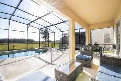 Discover a bright oasis with natural light streaming into the screened patio, enhancing the stylish wicker furniture. Unwind by the sparkling pool and take in the expansive green views, ensuring each moment feels truly special.