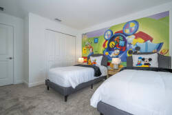 Bright decor and cozy twin beds with plush white bedding create a playful atmosphere in this whimsical bedroom, making it a delightful retreat for kids to unwind after a day full of adventures.