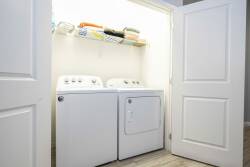 Enjoy convenience in this modern laundry nook with a washer and dryer. The bright space features organized shelves, keeping all your essentials easily accessible for a comfortable stay.