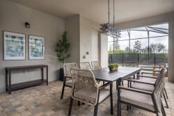 Experience the stunning dining area with a sleek table and stylish open-weave chairs. Enjoy the natural light pouring in through large screens, creating a seamless connection to the beautiful outdoor views.