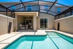 Step outside to your private oasis, where a shimmering pool invites you to relax under the sun. The covered patio features a sleek dining set, perfect for enjoying meals al fresco while surrounded by a tranquil atmosphere.